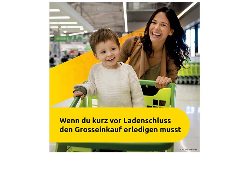 Frau mit dunkelbraunen Haaren schiebt ihr Sohn im weissen Pullover im Einkaufswagen. Text: