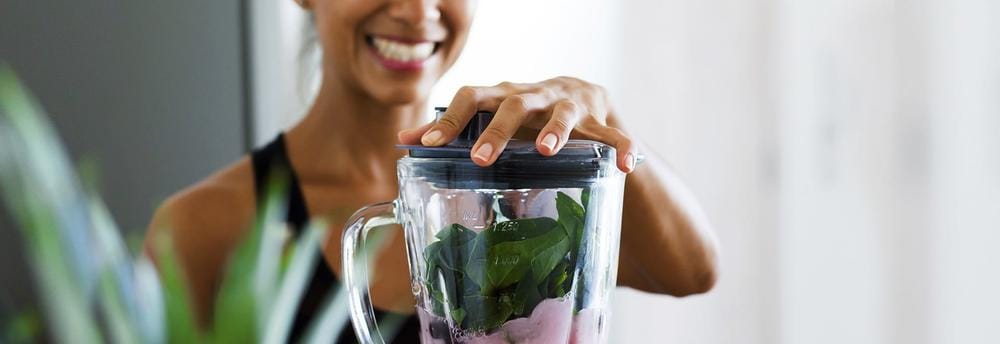 Jeune femme préparant un smoothie énergétique