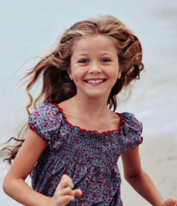 Une petite fille souriante aux cheveux longs